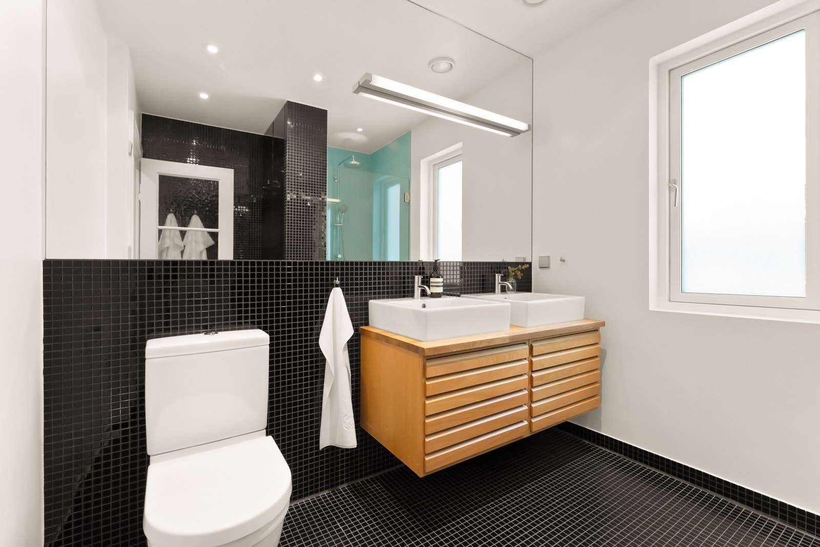 Badet i andre etasje får dagslys fra et vindu med foliert glass, og har en skreddersydd utforming som passer til husets karakter. Galleribilde