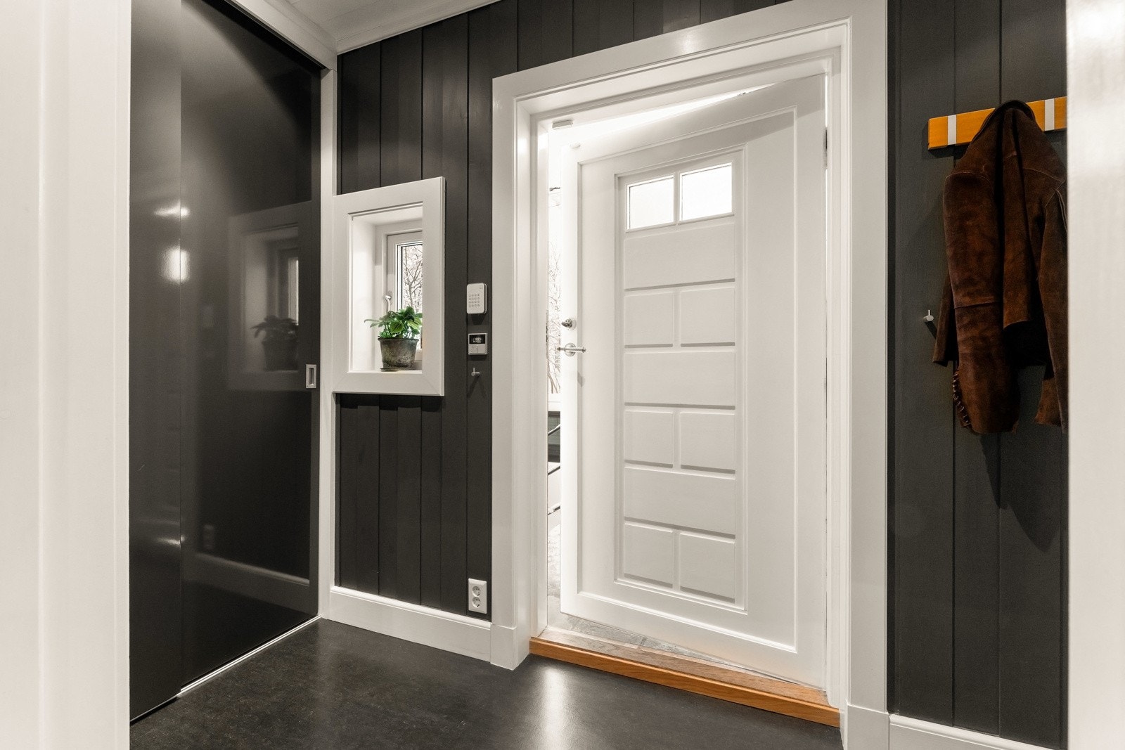 Den originale ytterdøren er hvitmalt på innsiden med vrider i messing og to små glassfelt. Galleribilde