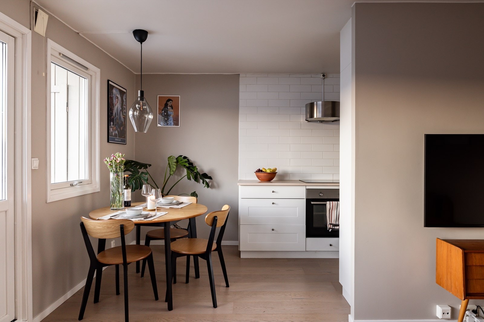 Mellom kjøkken- og stuesonen er det perfekt å innrede med et spisebord. Galleribilde