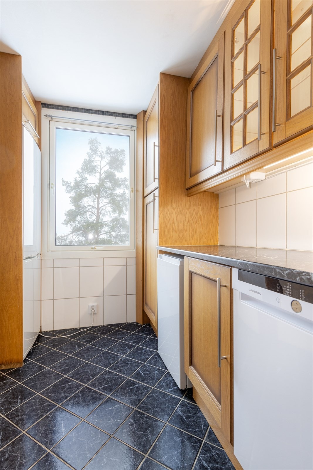 Det er etablert lekkasjevakt i benkeskap og komfyrvakt (2024) over kokesone. Kjøkkenet har flis på både vegger og gulv. Galleribilde