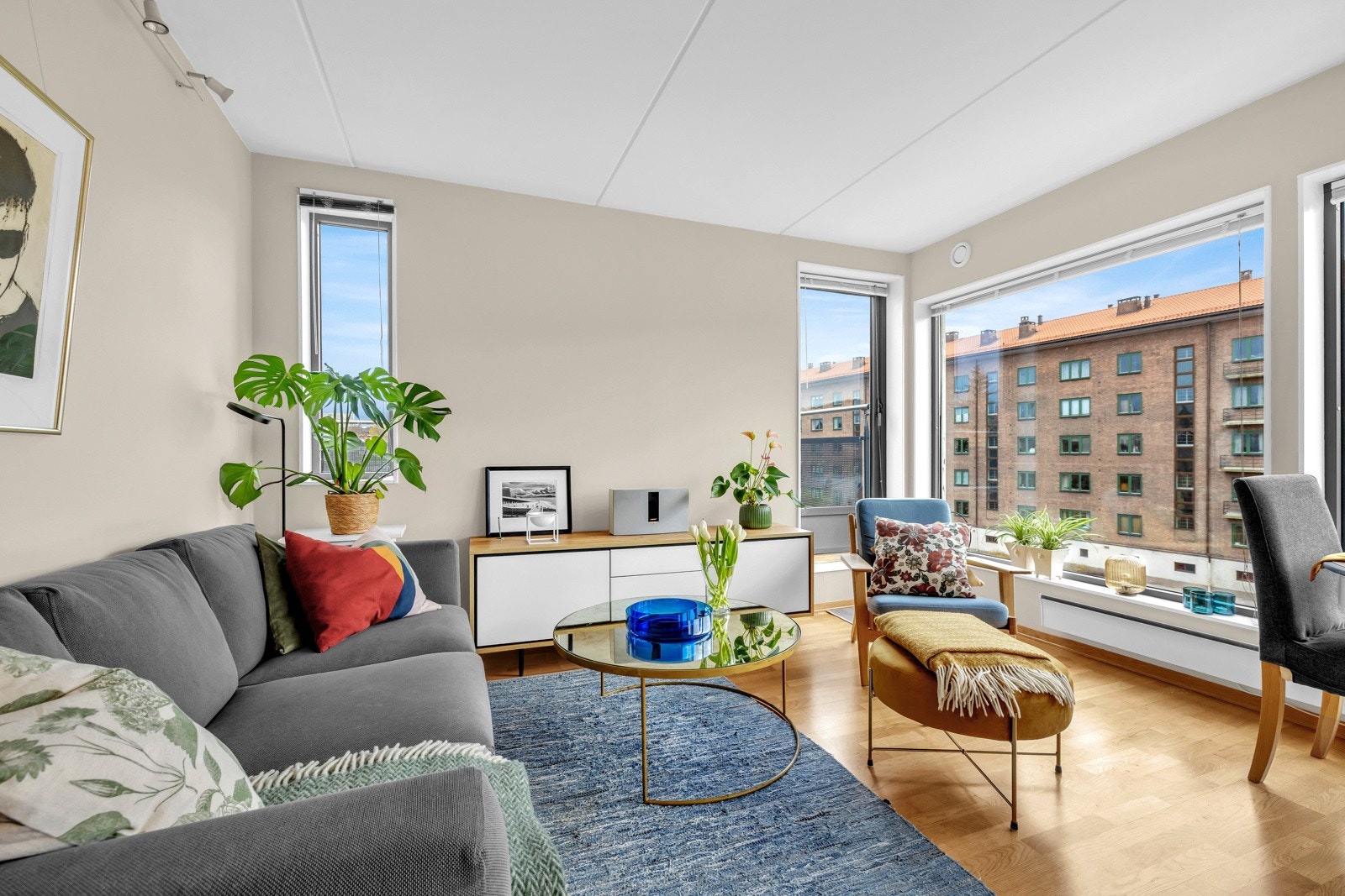 Leilighetens stue er lys og delikat med store vindusflater som gir en luftig atmosfære Galleribilde