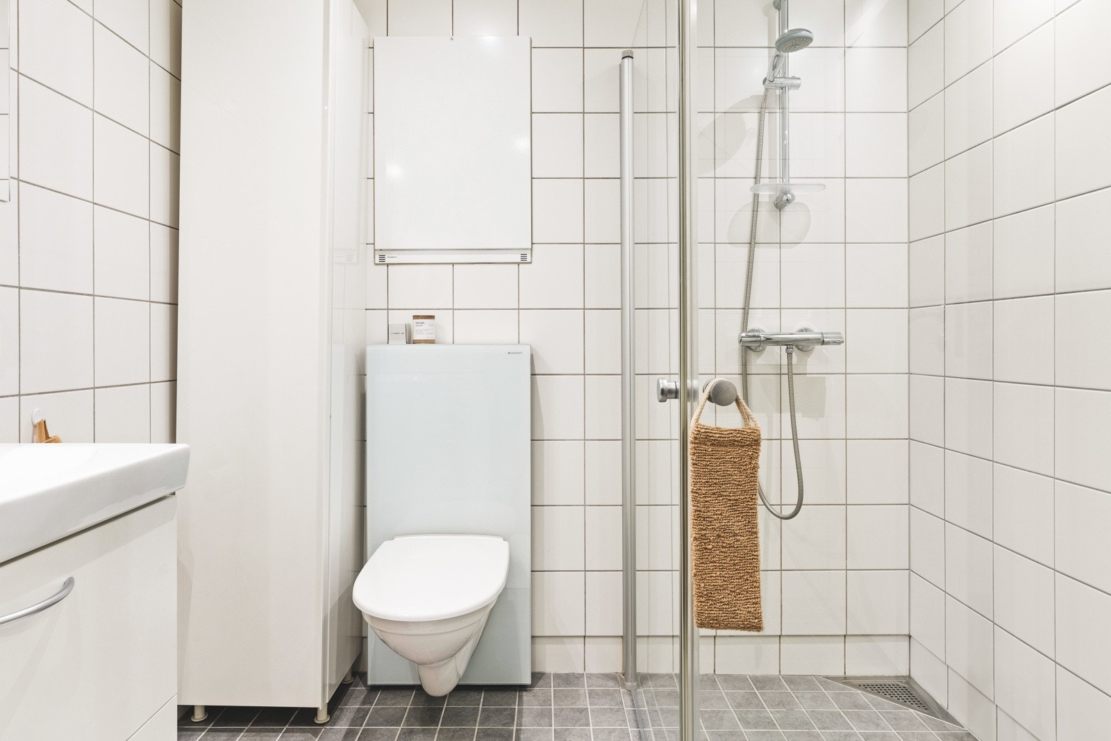 Leilighetens bad er helfliset bad og har en slett malt himling, innfelte downlights i himling og vannbåren gulvvarme. Galleribilde