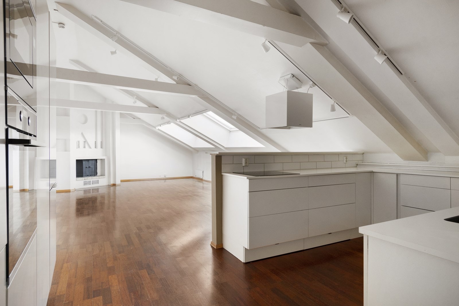 Lyst kjøkken med lyse overflater og integrerte hvitevarer Galleribilde