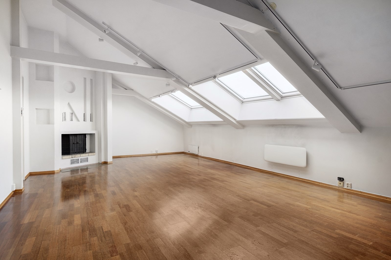 Stue med peis, lysmalte overflater og parkett på gulv Galleribilde