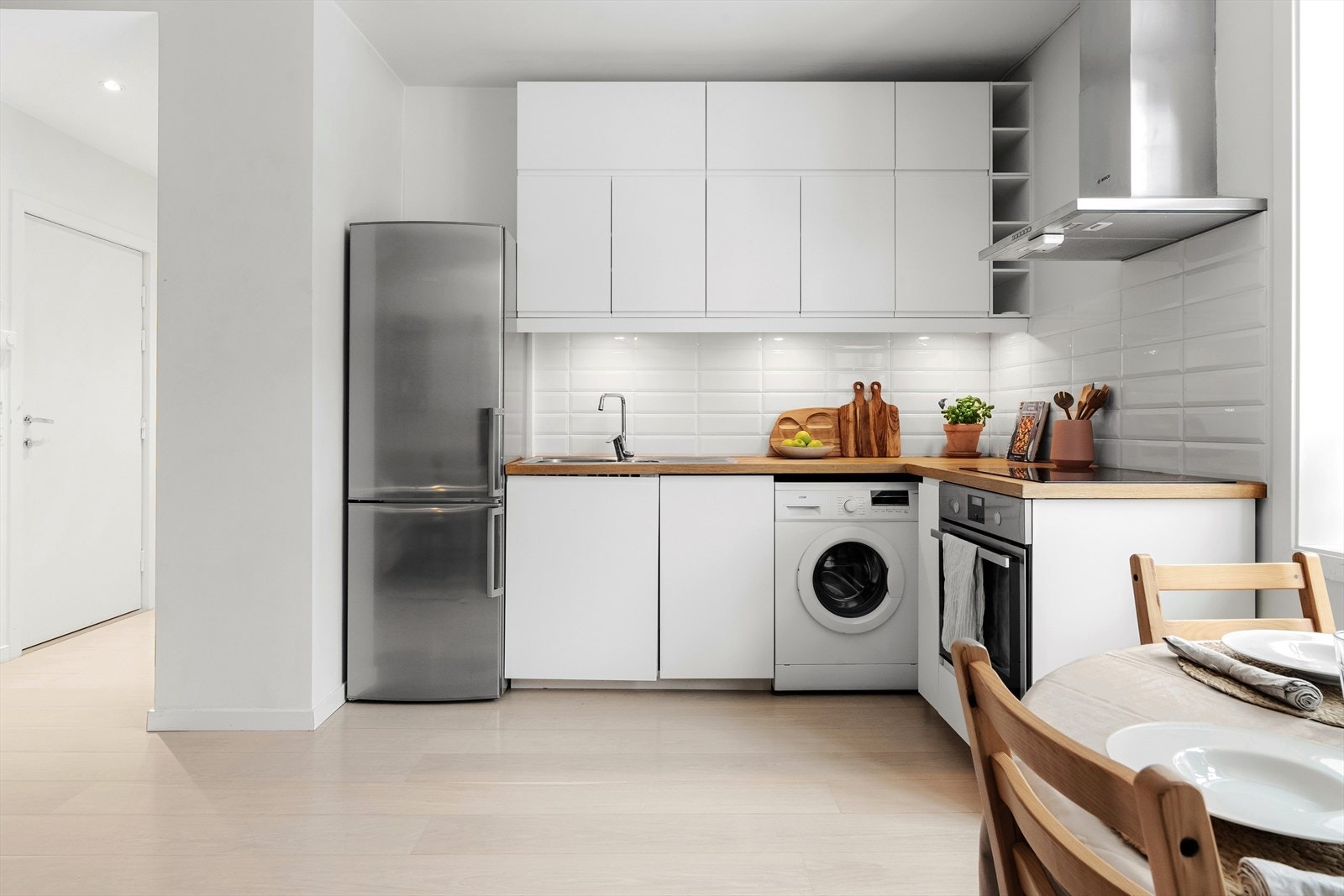 Kjøkkenet har glatte fronter, heltre benkeplate med nedfelt vask- og skyllekum, samt stilrene fliser over benken. Galleribilde