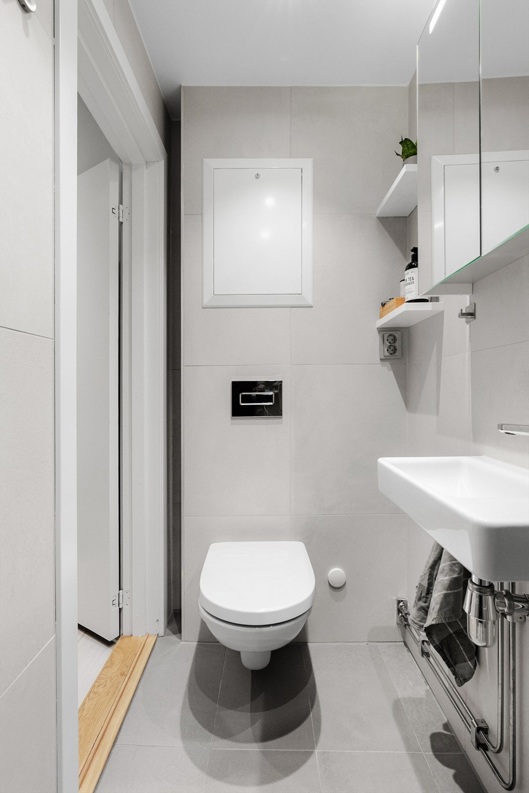 Badet er innredet med vegghengt klosett, servant med innredning og dusjhjørne med svingbar glassdør. Galleribilde