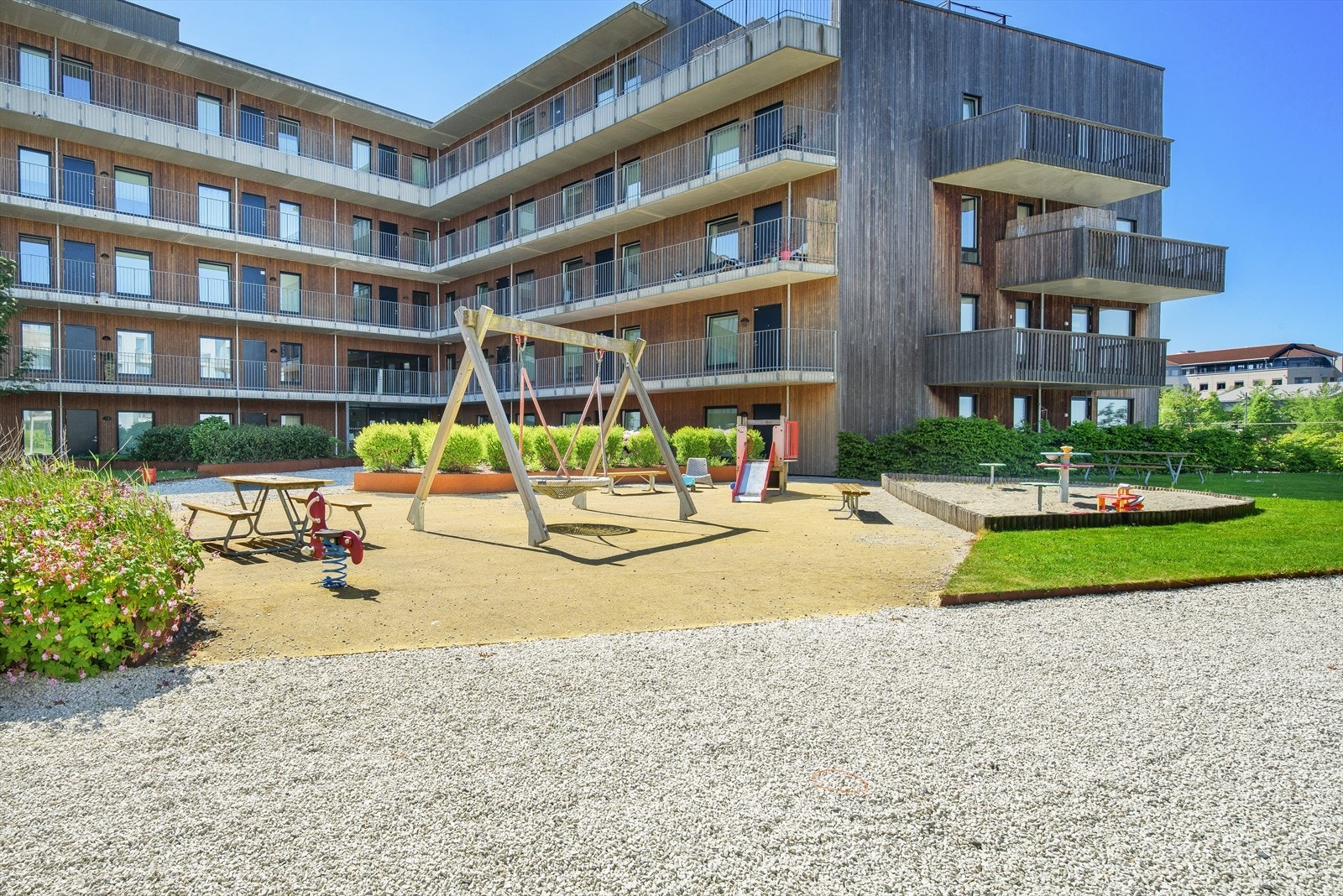 Leilighetsbygget er omkranset av flott uteområde med flere koselige lekeplasser, fint plenområde og felles sittegrupper Galleribilde