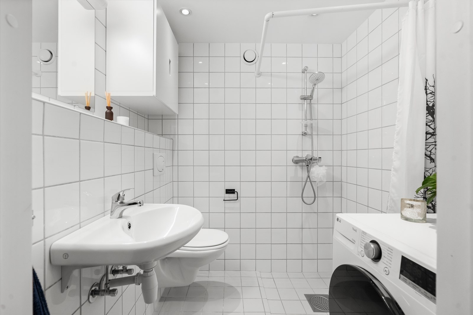 Baderommet har flis på gulv og på vegger, samt malte plater i himling med spotter. Det er også lun gulvvarme. Galleribilde