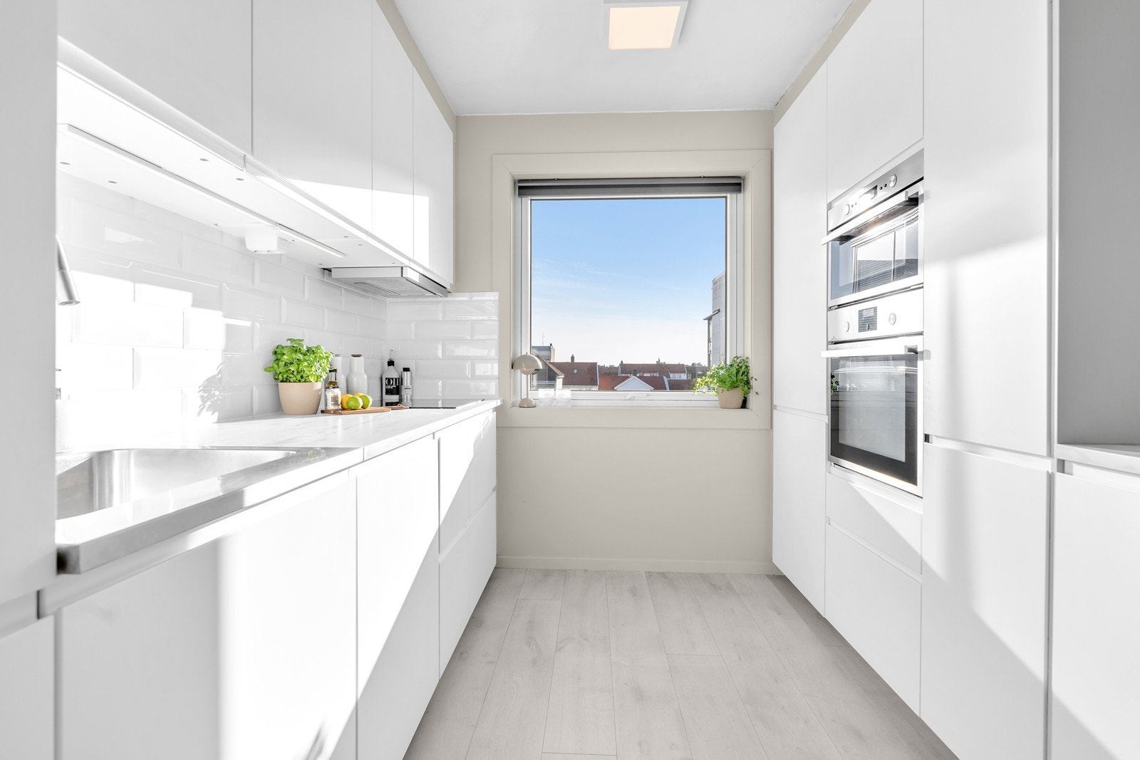 Stilrent kjøkken fra IKEA med integrerte hvitevarer og nyere benkeplate Galleribilde