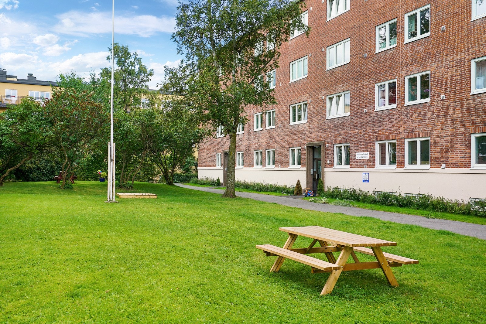 Grønne og frodige fellesarealer med sittegrupper og lekeapparater. Galleribilde