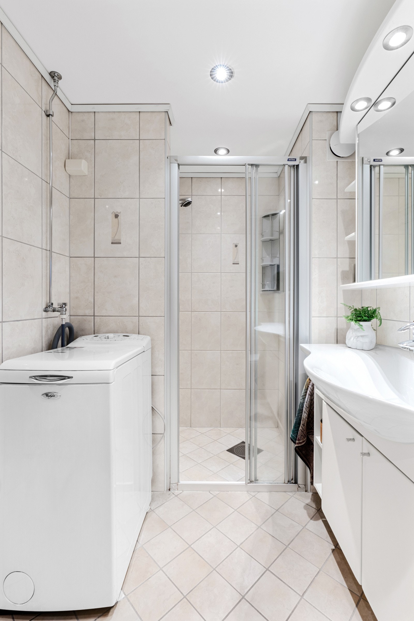 Det romslige badet har et vegghengt toalett, en dusjnisje og opplegg for vaskemaskin. Galleribilde