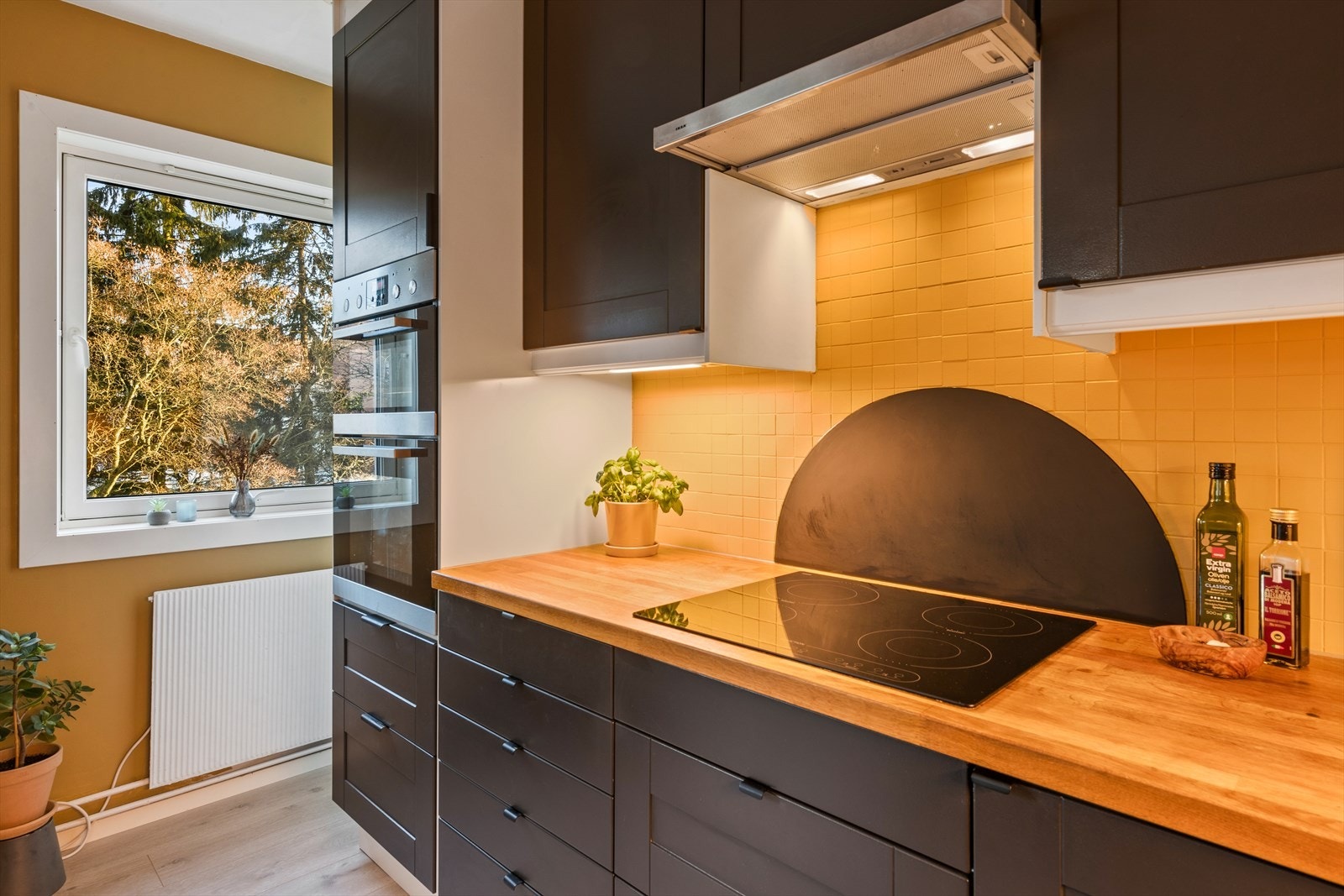 Dette kjøkkenet er praktisk utformet med mye skap- og benkeplass. Galleribilde