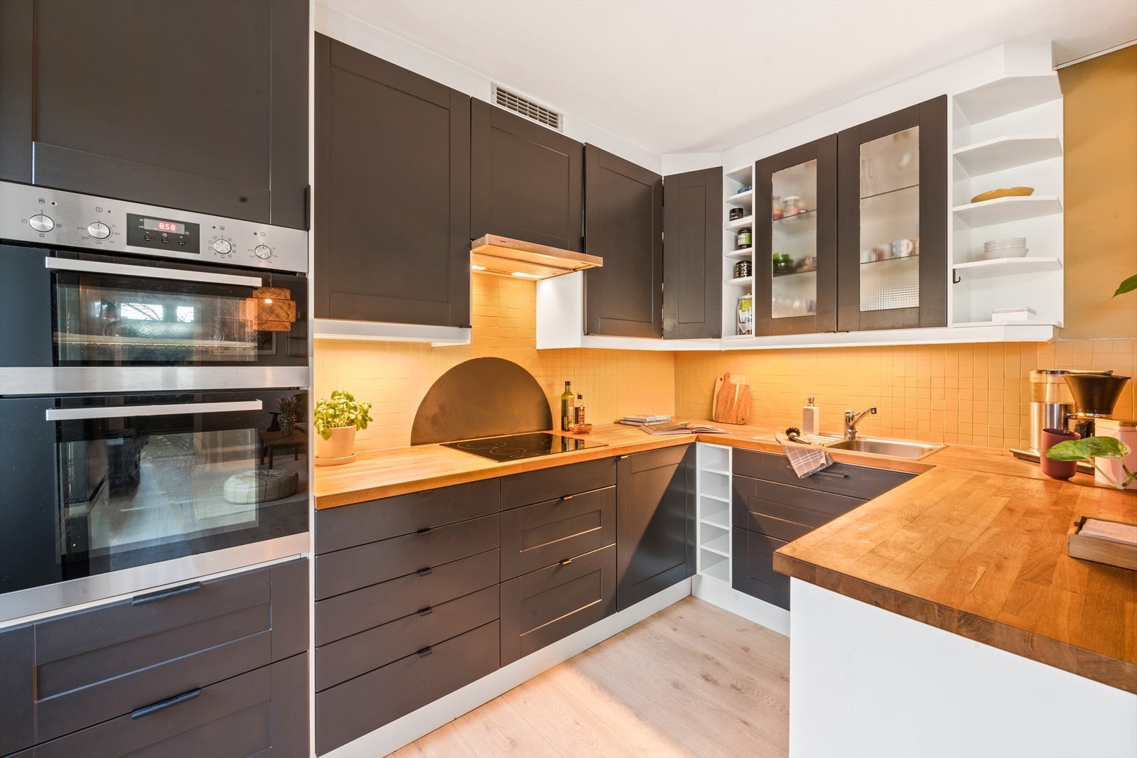 Kjøkkeninnredningen har klassiske, profilerte fronter i sort, og en solid heltre benkeplaten med nedfelt vask. Galleribilde