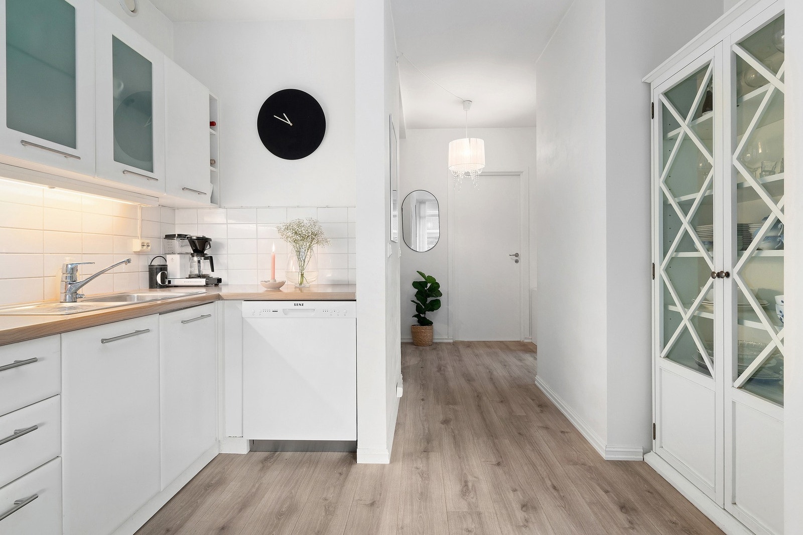 Leiligheten har åpen planløsning mellom stue og kjøkken og innredningen på kjøkken har både over- og underskap, med frostede glass i overskap Galleribilde