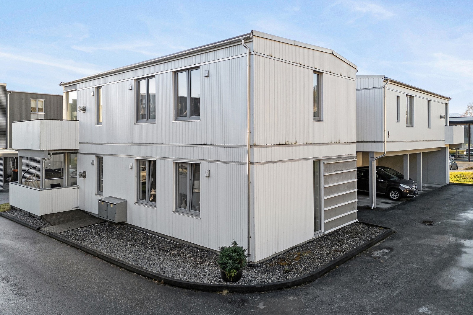 Man har flat tilkomst via asfaltert veg og parkering i carport på baksiden Galleribilde