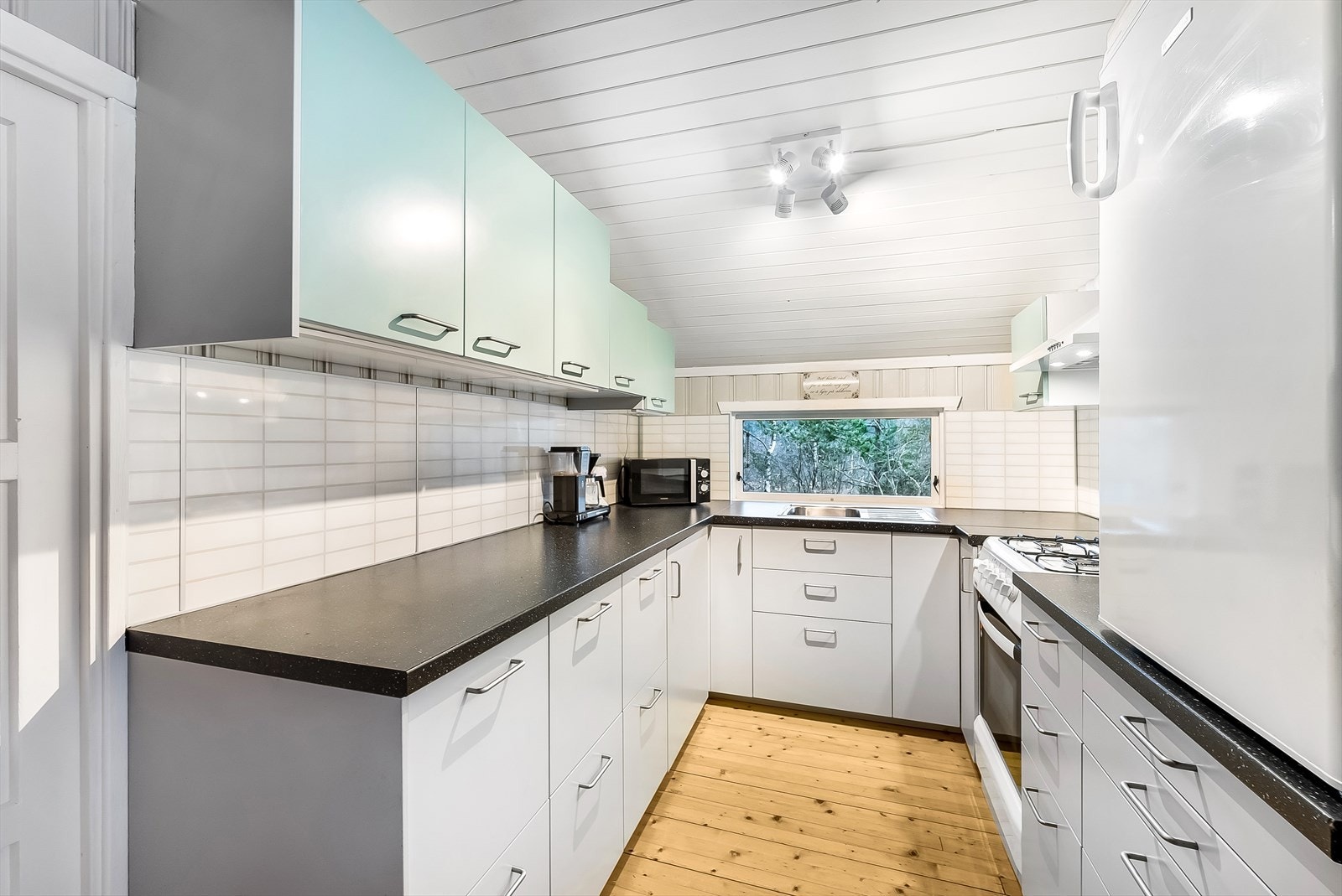 Kjøkkeninnredning fra Ikea med enkeltstående kjøleskap og gasskomfyr, disse medfølger handelen. Galleribilde