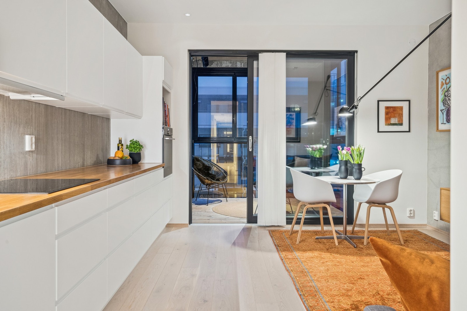 Åpen stue/kjøkken- løsning med skyvedør til innglasset balkong. Galleribilde