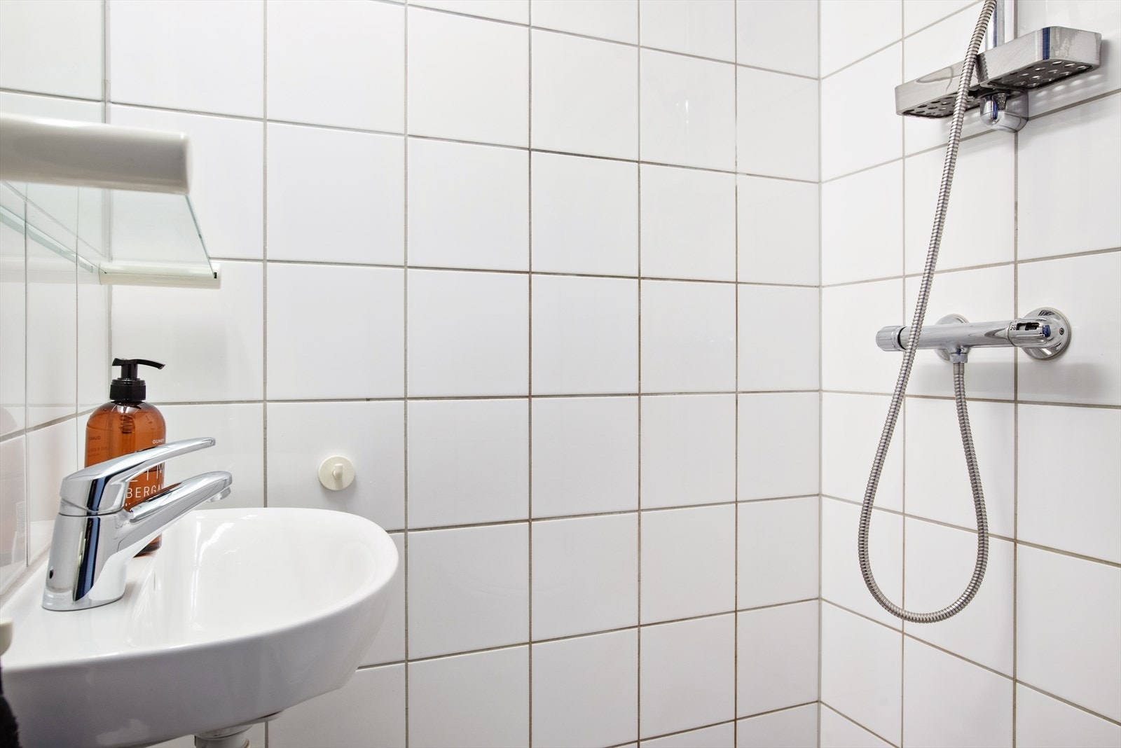 Badet er utstyrt med dusjhjørne, servant og vegghengt toalett Galleribilde