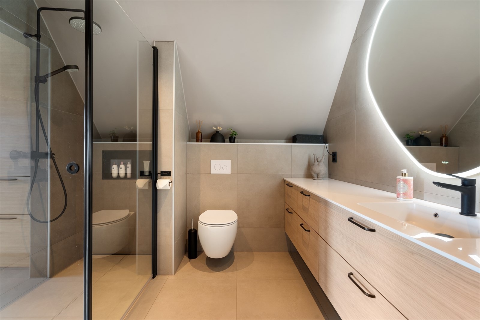 Badet har dusjhjørne, veggmontert toalett, og baderomsinnredning med nedfelt servant. Galleribilde