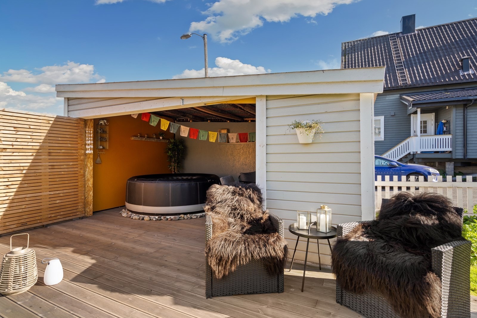 På tomten står en utebod med tilhørende platting. Her er det laget et koselig område for avslapning. Galleribilde