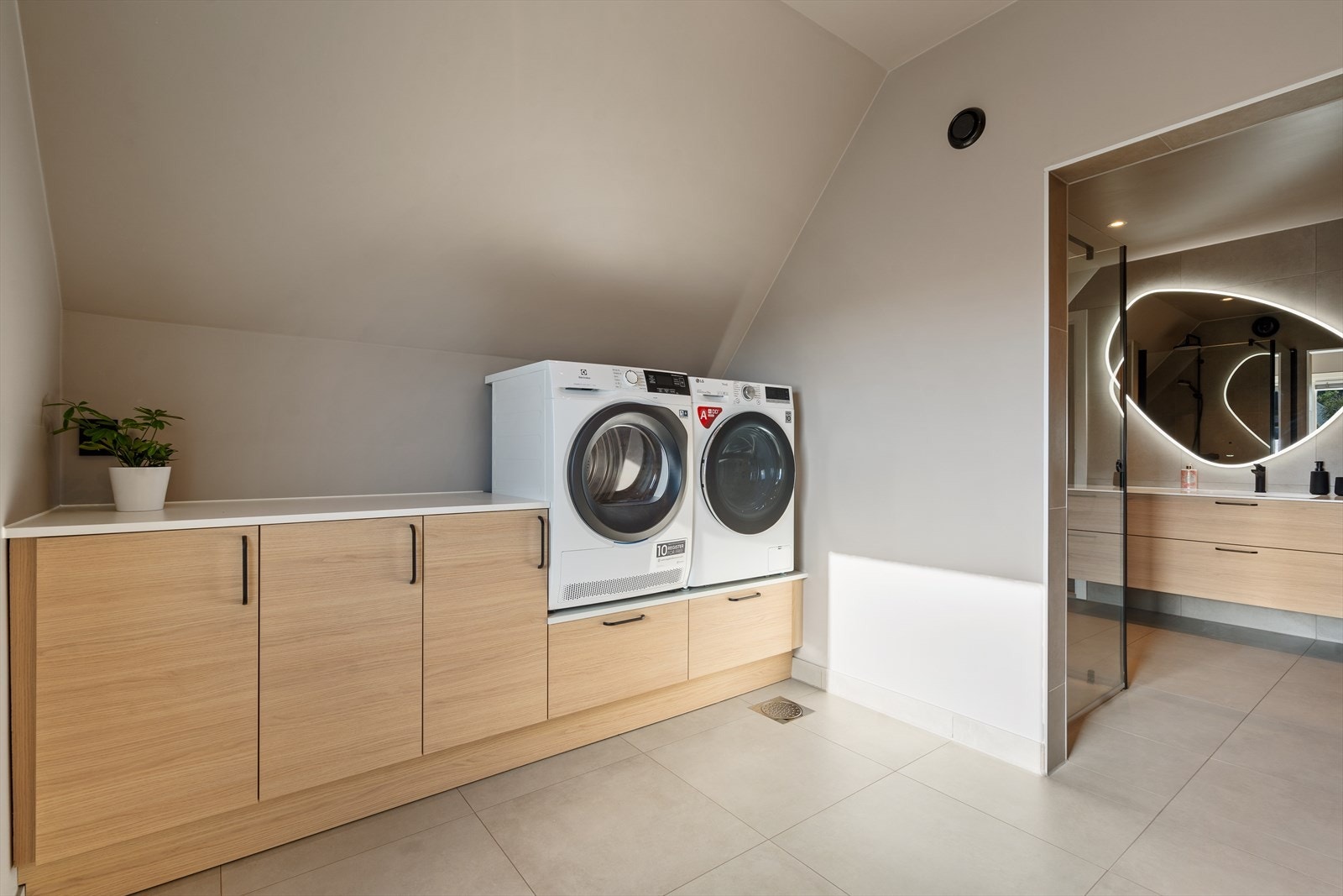 Praktiske uttrekkbare skuffer under vaskemaskin og tørketrommel hvor du kan plassere skittentøysdunken for bedre arbeidshøyde. Galleribilde