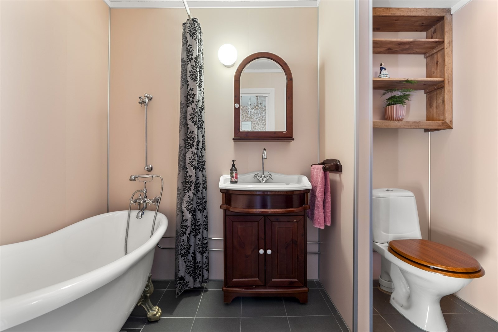 Funksjonelt bad renovert i 2016 med nye overflater av flis på gulv og baderomsplater på vegg. Rommet er innredet med gulvmontert klosett, vask med underskap og speil, og badekar med dusjmulighet. Elektriske varmekabler i gulv. Galleribilde