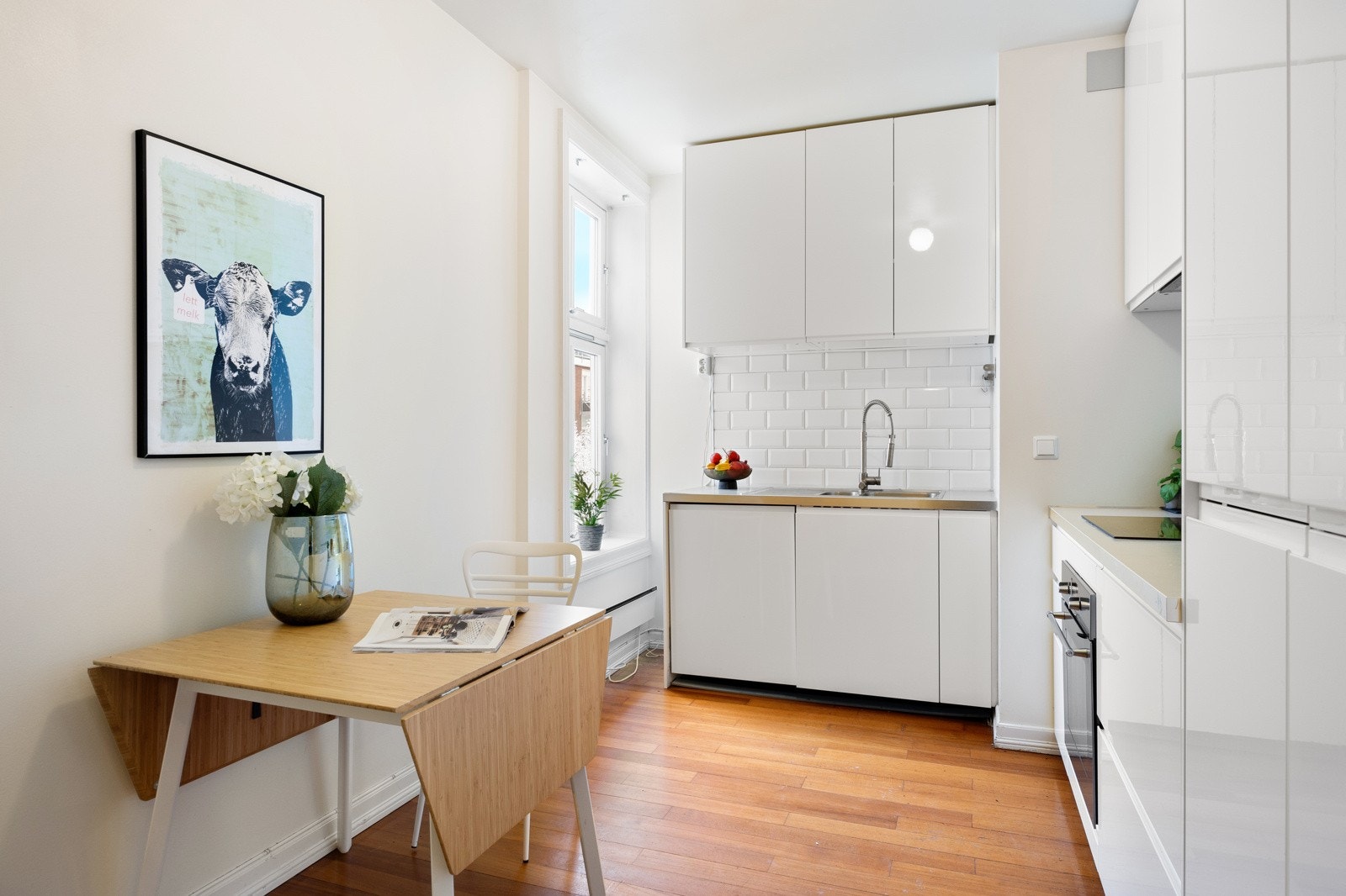 Innholdsrikt Ikea-kjøkken med L-utforming som gir gode arbeidsflater og plass til spisebord. Galleribilde