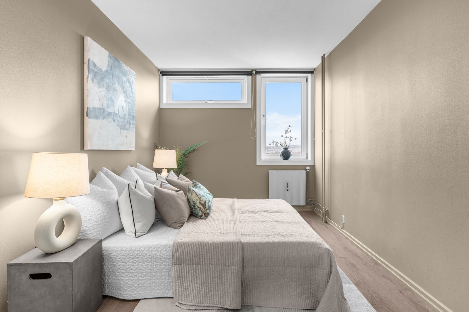 Begge soverommene er holdt i duse fargetoner som står godt til gulvene, og det er montert rullegardiner i vinduene. Galleribilde