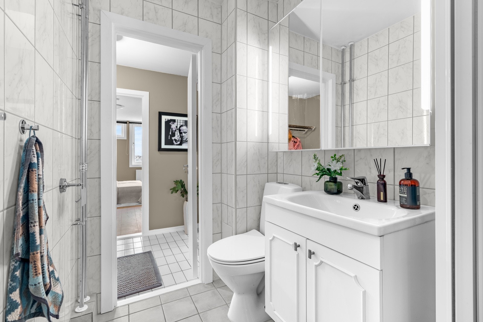 Baderomsinnredningen har hvite fronter og består av en heldekkende servant på en skapseksjon og et dobbelt speil skap med integrert belysning. Det er også fellesvaskeri. Galleribilde