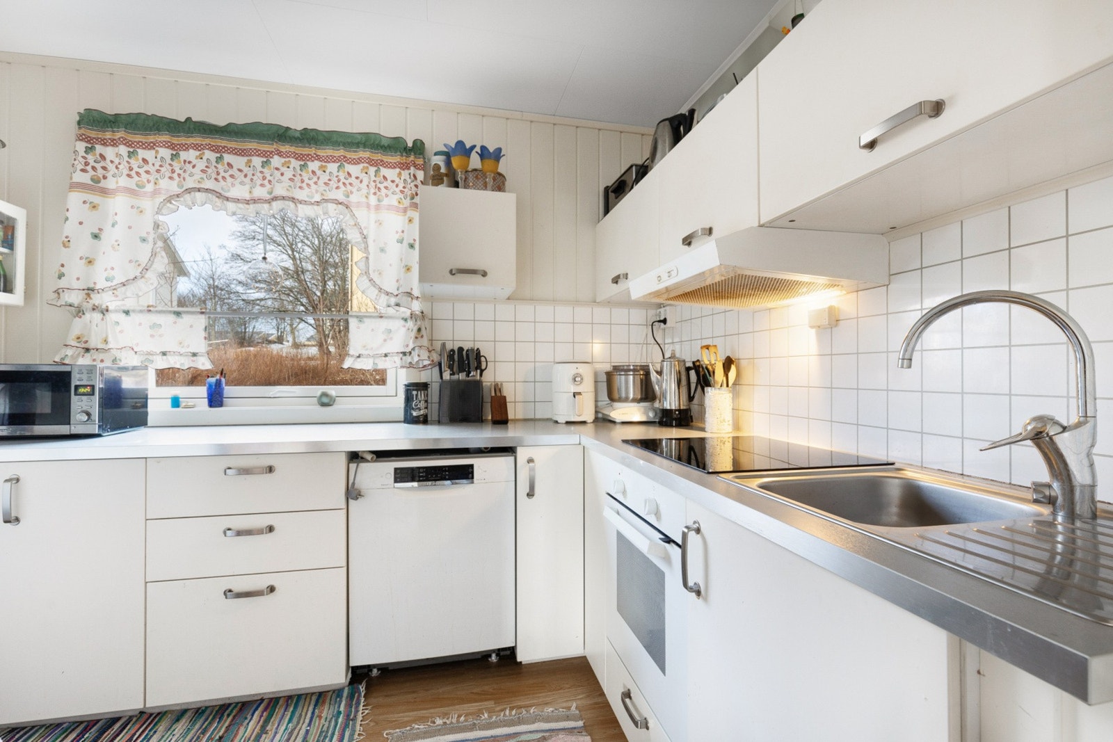 Kjøkkenet holder et tidløst preg med sine lyse fronter og har godt med skap og benkeplass Galleribilde