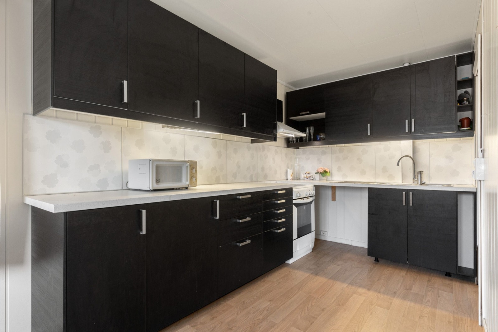 Kjøkkenet har godt med skap og benkeplass Galleribilde