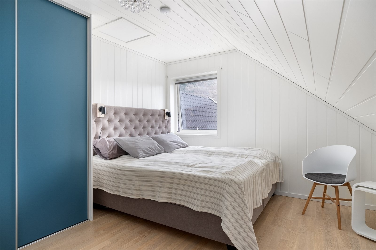 Lyst, tiltalende soverom med skråtak og moderne skyvedørsgarderobe. Galleribilde