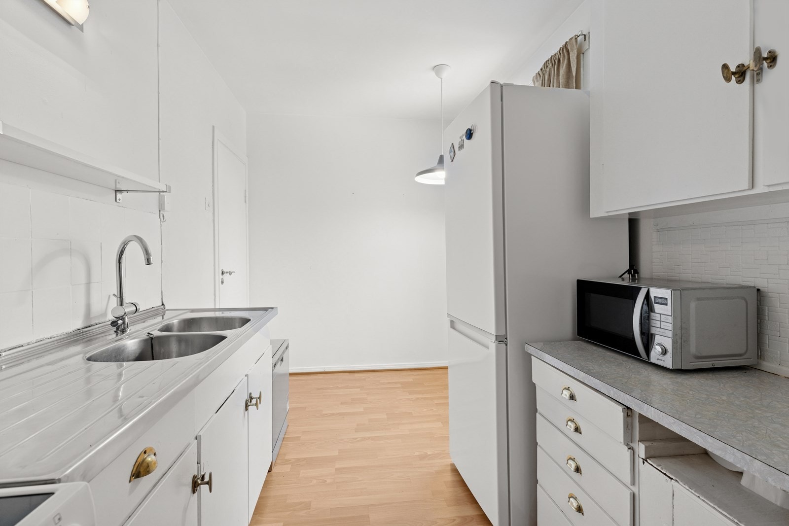 Eldre innredning med glatte fronter. laminatbenkeplate og heldekkende servantplate av stål. Galleribilde