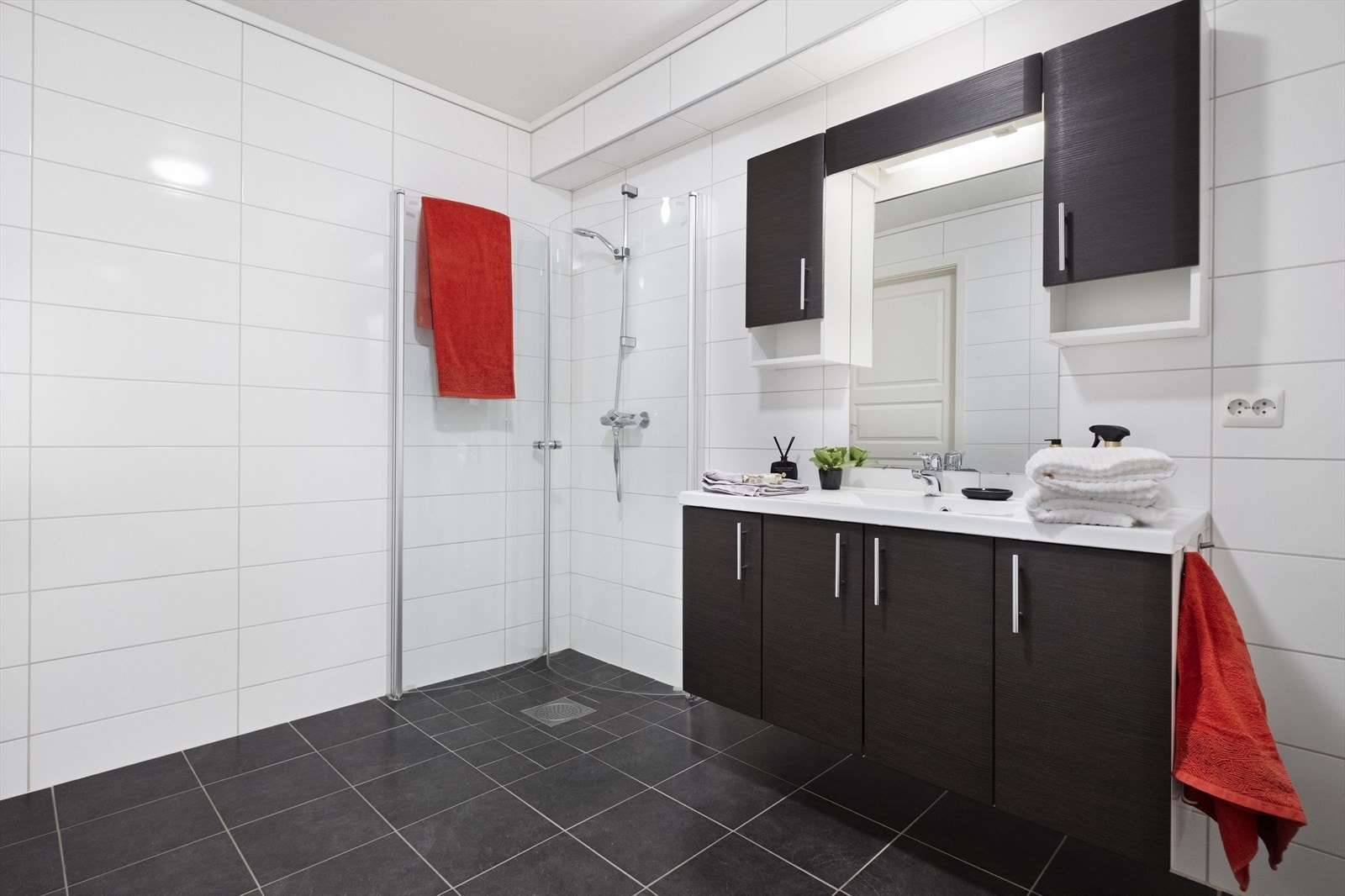 Badet har dusjhjørne, innredning med med servant, vegghengt toalett og opplegg for vaskemaskin. Galleribilde