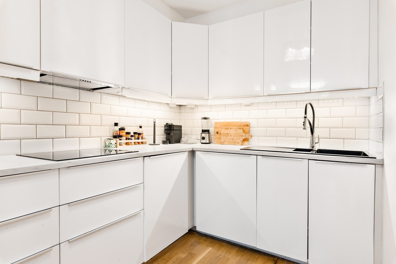 Pent kjøkken med innredning fra IKEA. Det er integrerte hvitevarer som platetopp, stekeovn, mikroovn og oppvaskmaskin, samt plass til frittstående kjøle-/fryseskap. Galleribilde