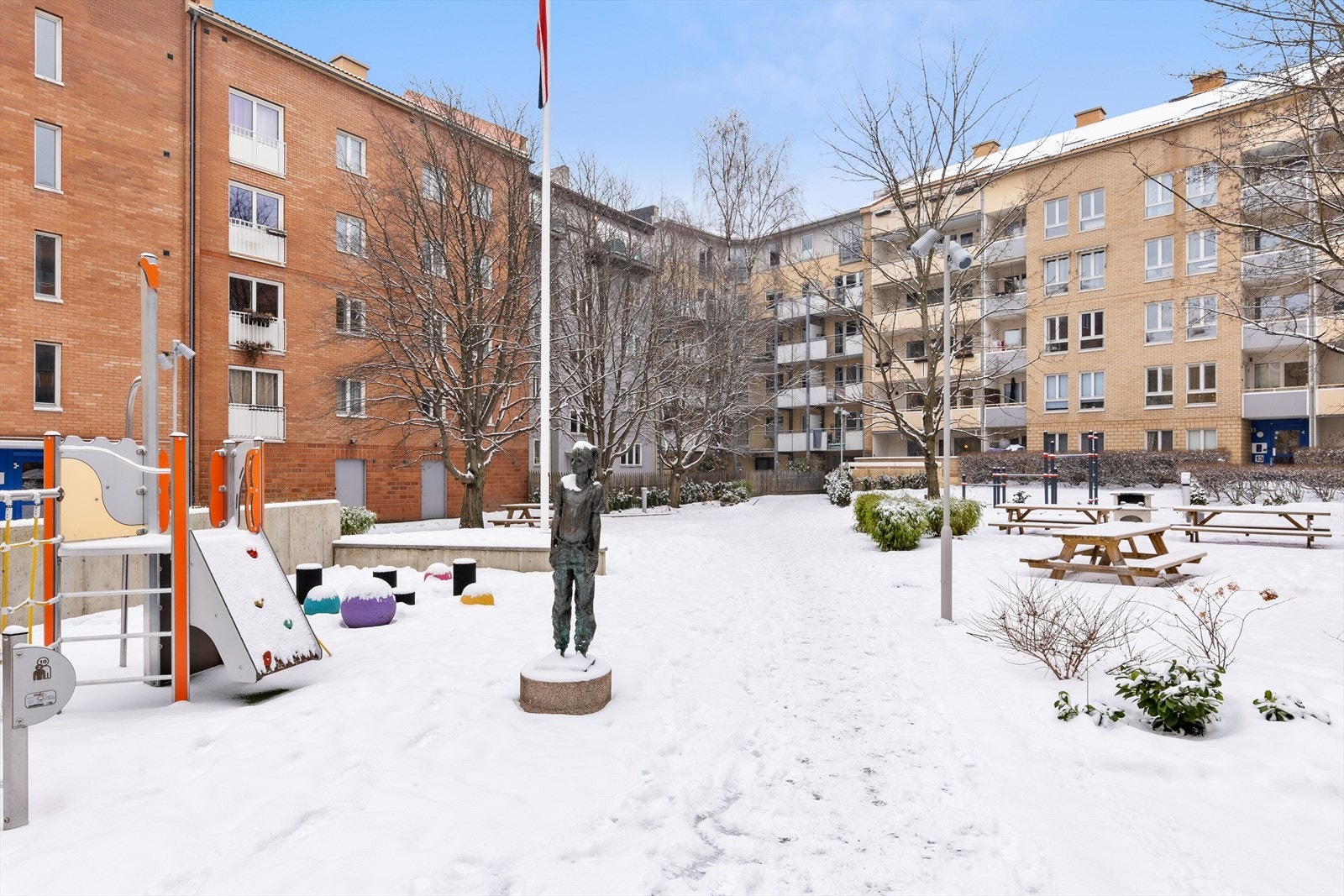 Pent opparbeidede fellesarealer med beplantning, sittegrupper og lekeapparater. Galleribilde