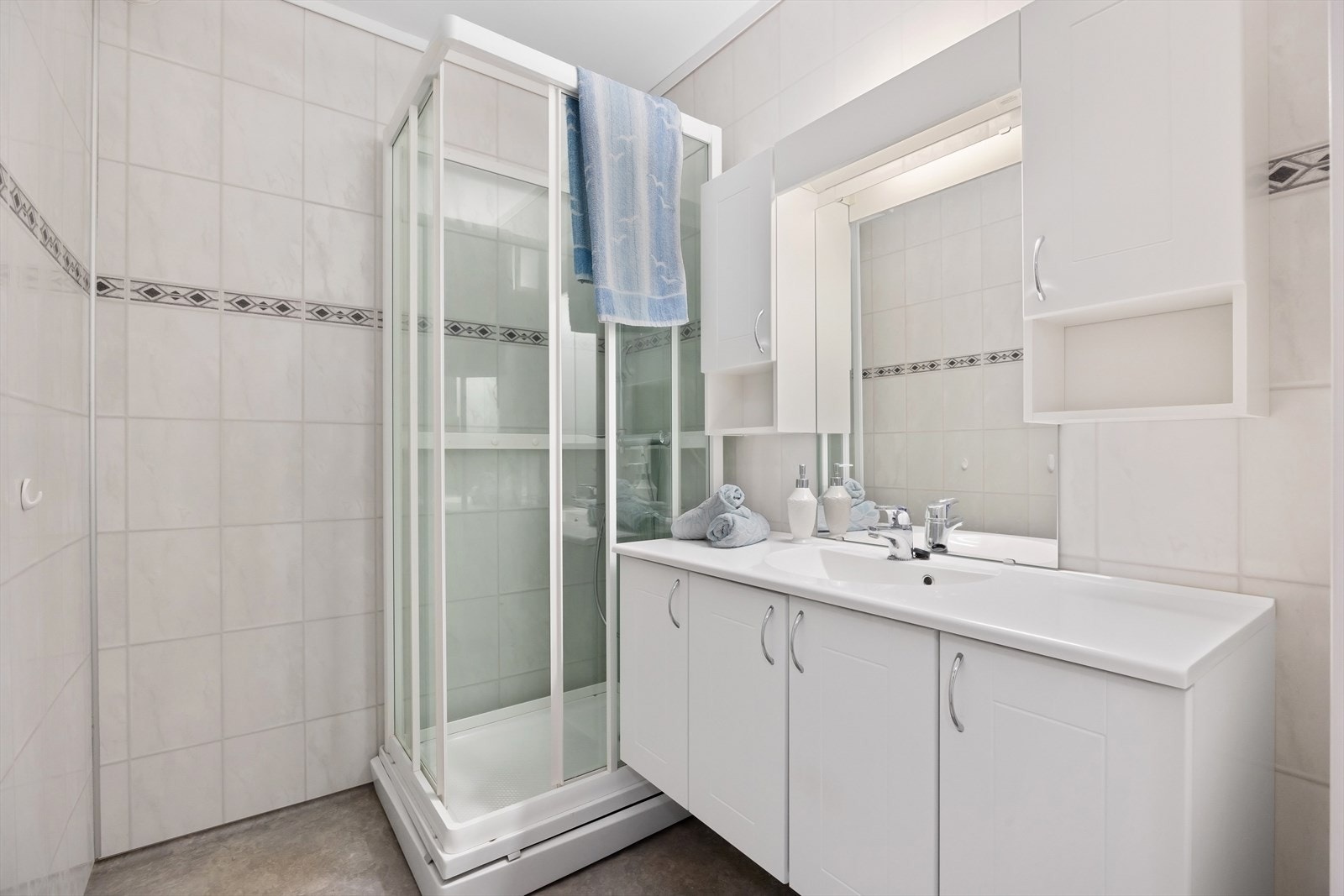 Badet er av eldre opprinnelse, med baderomsplater på veggene og gulvbelegg med varmekabler. Galleribilde