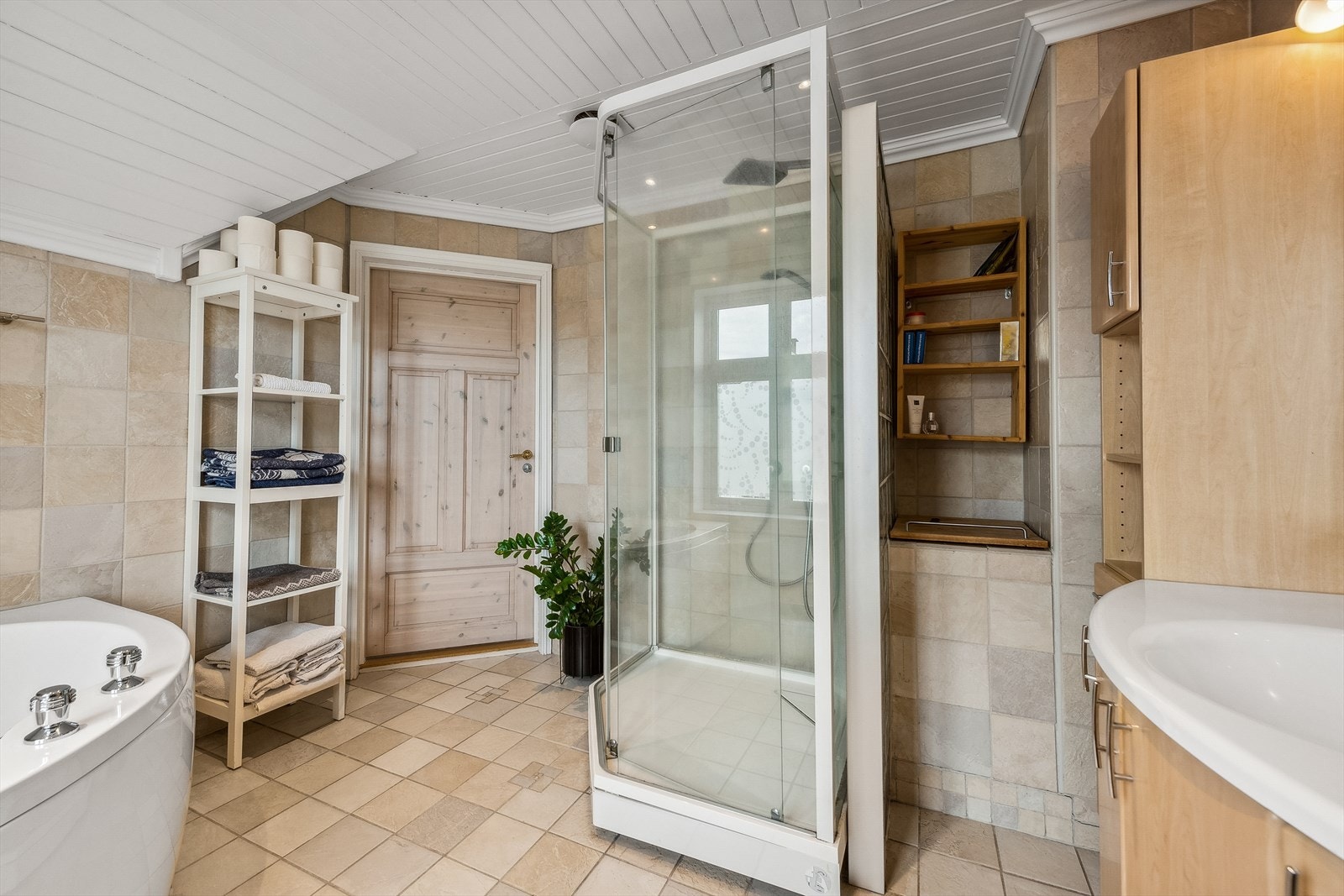 Badet er innredet med servant, vegghengt toalett, boblekar og dusjkabinett Galleribilde
