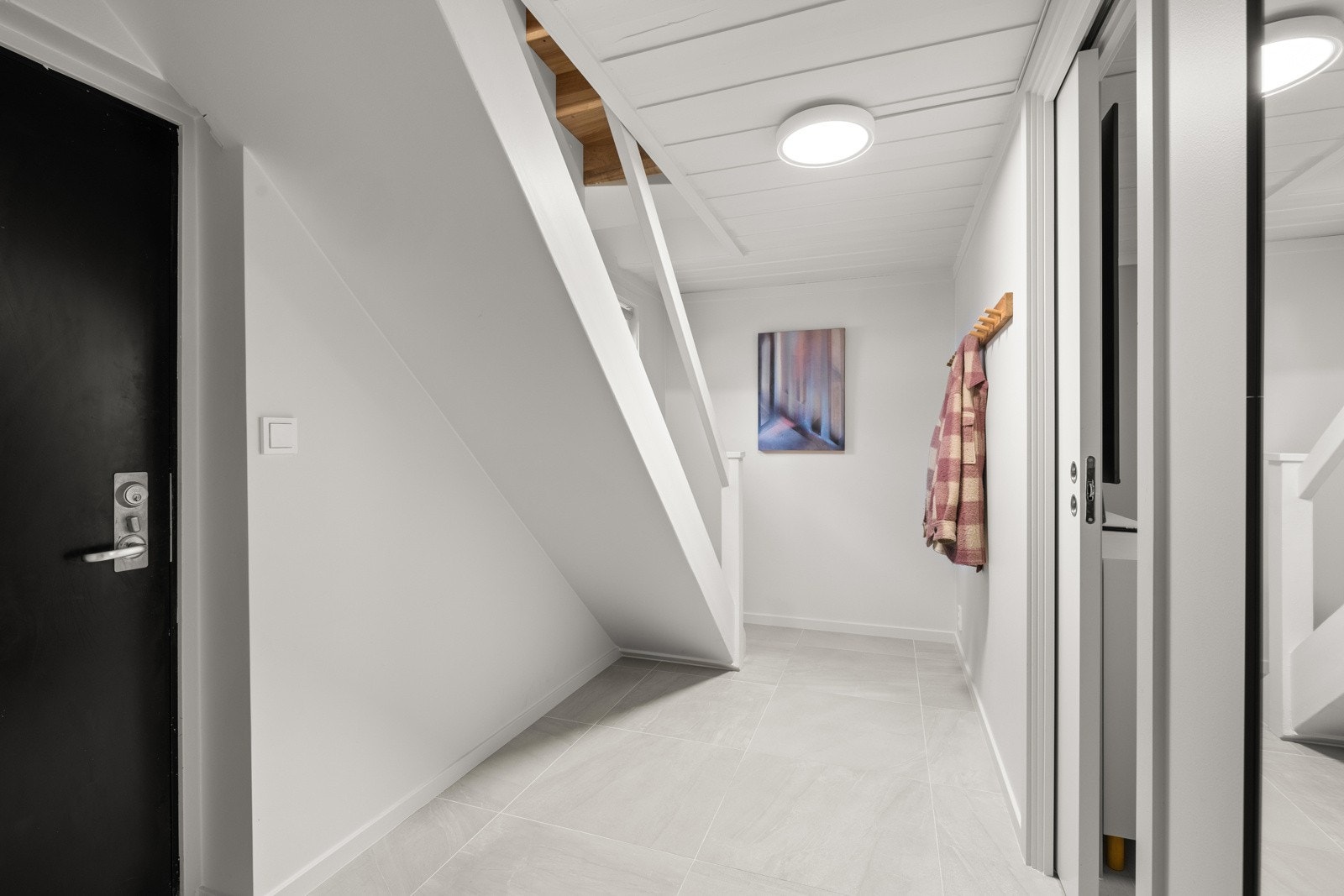 Inngangsdør til kjelleren med direkte tilgang til et stort og praktisk vaskerom/bad. Hele etasjen (bortsett fra bod) ble renovert i 2024. Galleribilde