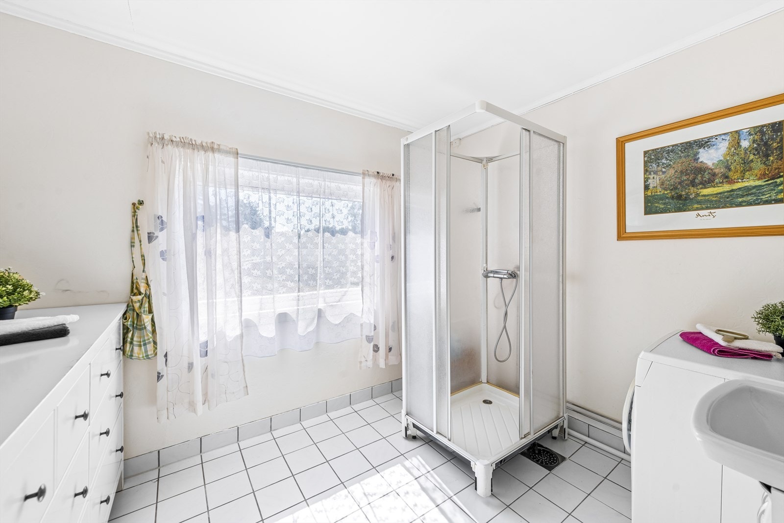 Badet har fliser på gulv, malt tapet over sokkelflis på vegger og malte slette plater i innvendig tak. Galleribilde