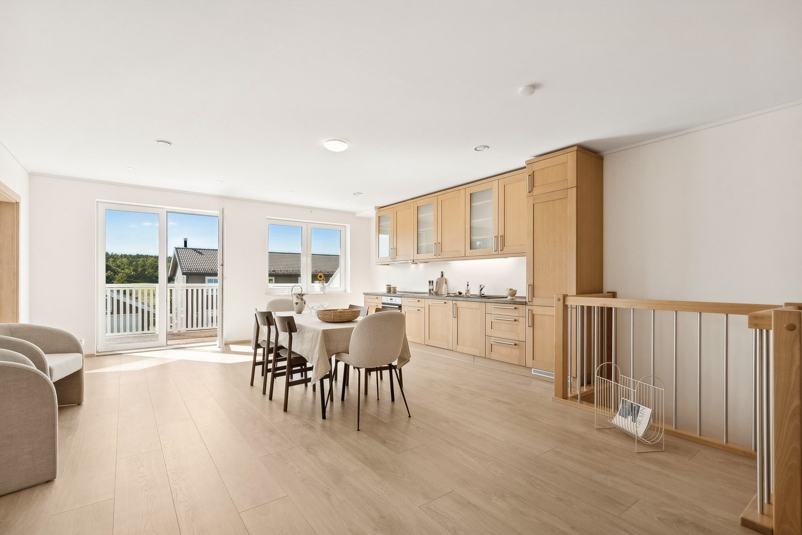 Kjøkkenet har en stilren innredning med profilerte eikefronter og benkeplate i laminat med nedfelt kjøkkenvask Galleribilde