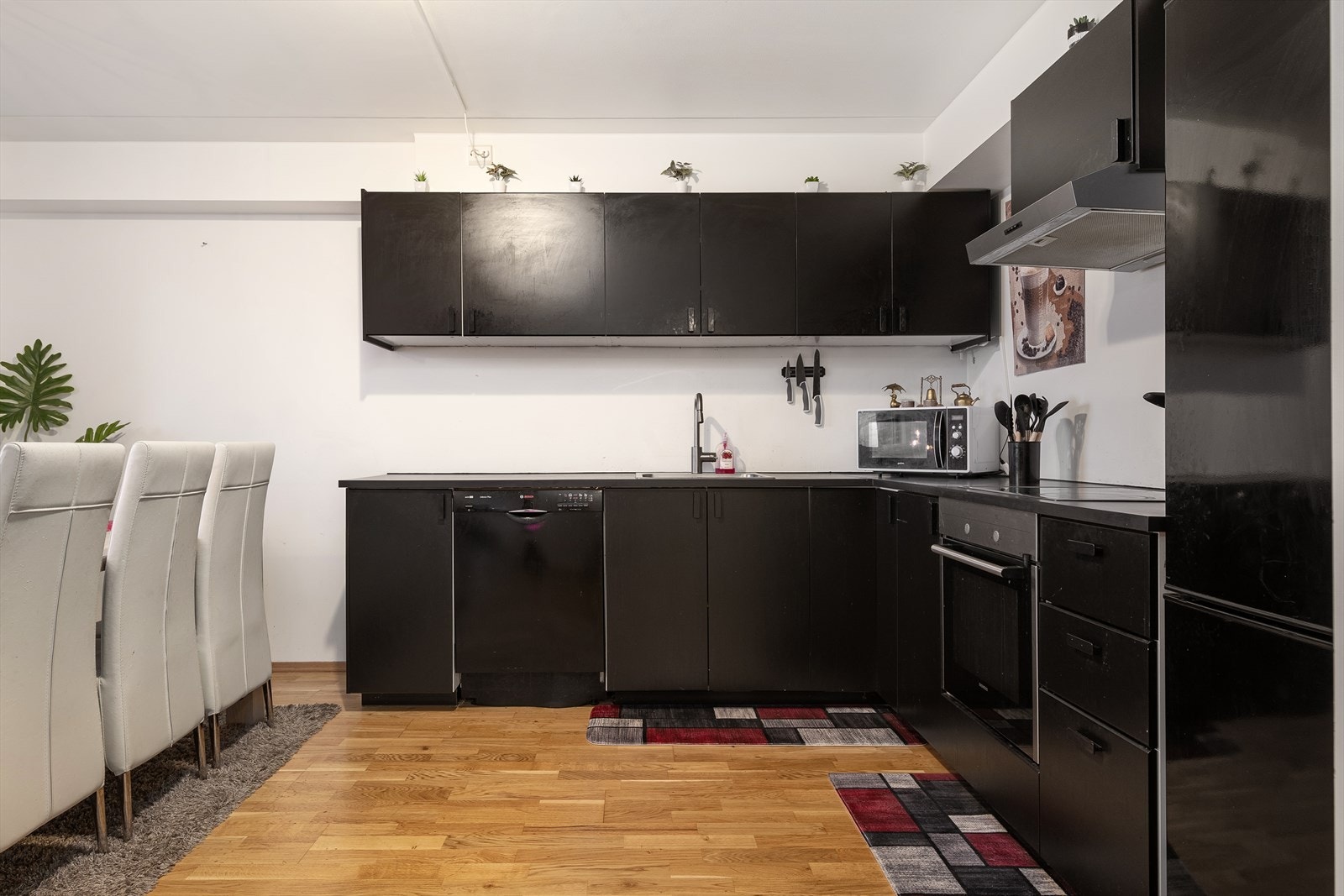Kjøkkenet er stilrent med sorte slette fronter og laminert benkeplate. Integrert stekeovn med platetopp, samt frittstående oppvaskmaskin og kjøleskap. Galleribilde