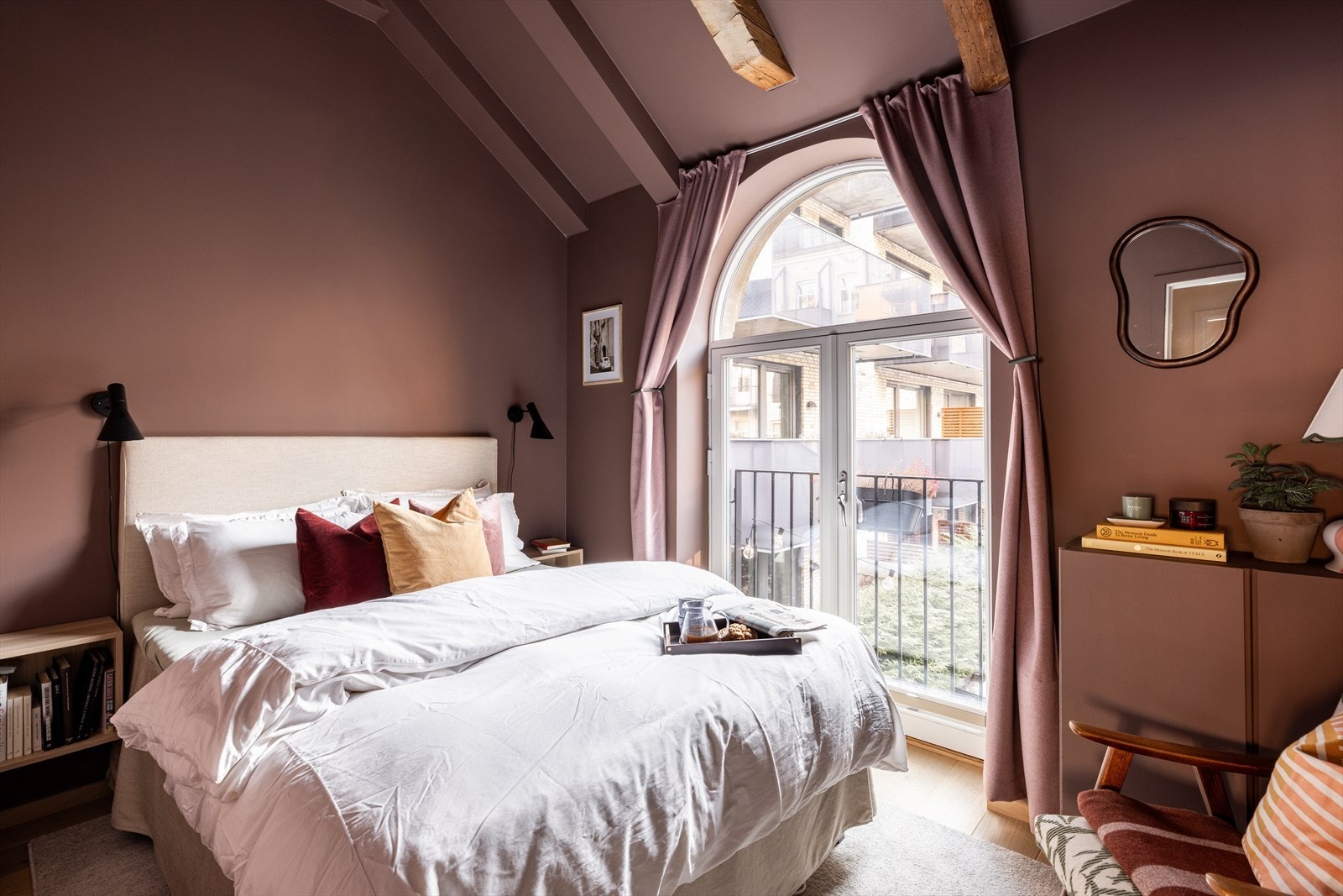 Et smakfullt og romslig soverom i varme farger, med god takhøyde Galleribilde