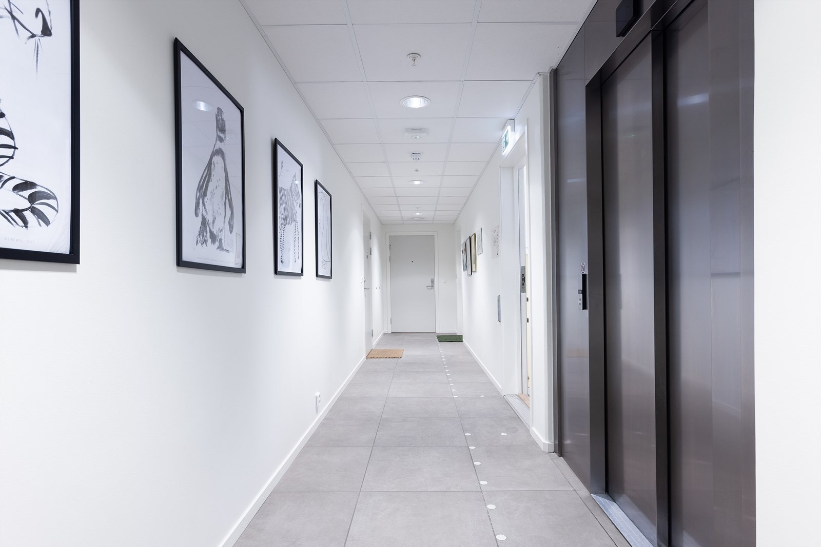 Leiligheten har enkel heisadkomst til leilighetsplan, rett opp fra felles inngangsparti og Røa Torg Galleribilde