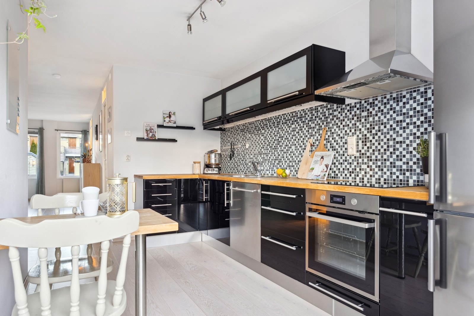 Kjøkkenet, som måler 10 kvm, har en tidløs innredning med sorte fronter i blank utførelse. Det er svært god oppbevaringsplass i over- og underskap, samt godt med benkeplass. Galleribilde