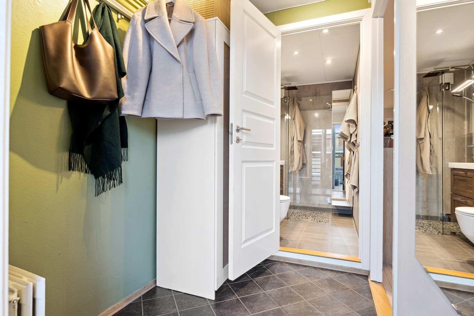 Du blir møtt av en romslig entré med god plass til oppbevaring av klær og sko. Herfra er det adkomst til leilighetens bad og videre tilkomst til stuearealet. Galleribilde
