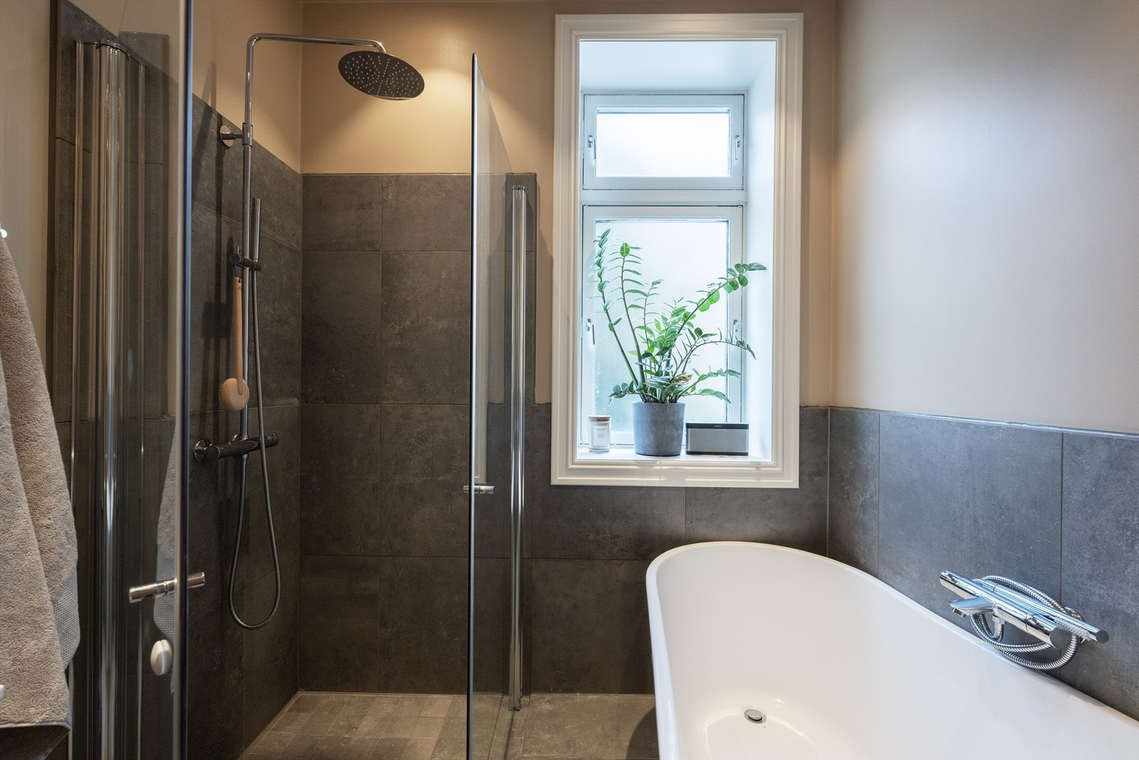 Badet er innredet med et frittstående badekar, dusjhjørne med dører i herdet glass med regnfallsdusj og hånddusj Galleribilde