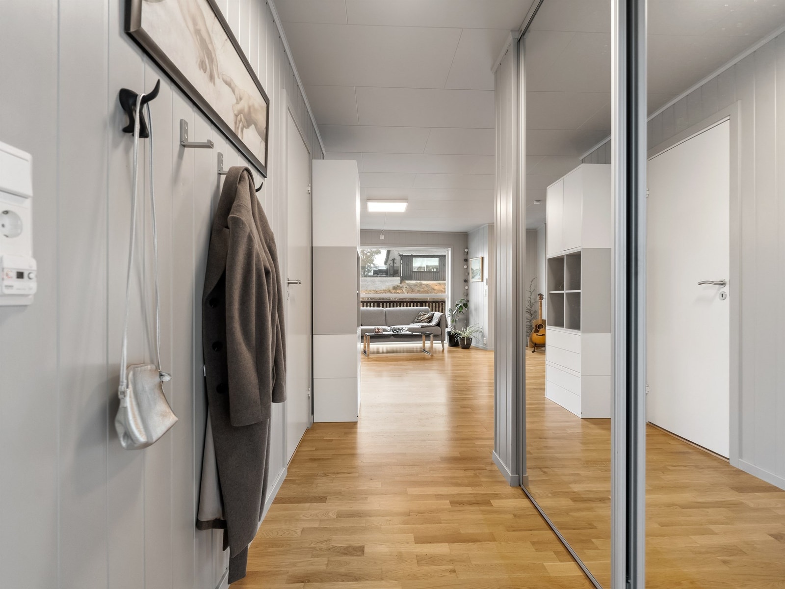 Speildørsgarderobe oppbevarer yttertøyet lett tilgjengelig i entreen, flere oppbevaringsmøbler er det rom for i gangen innenfor. Galleribilde