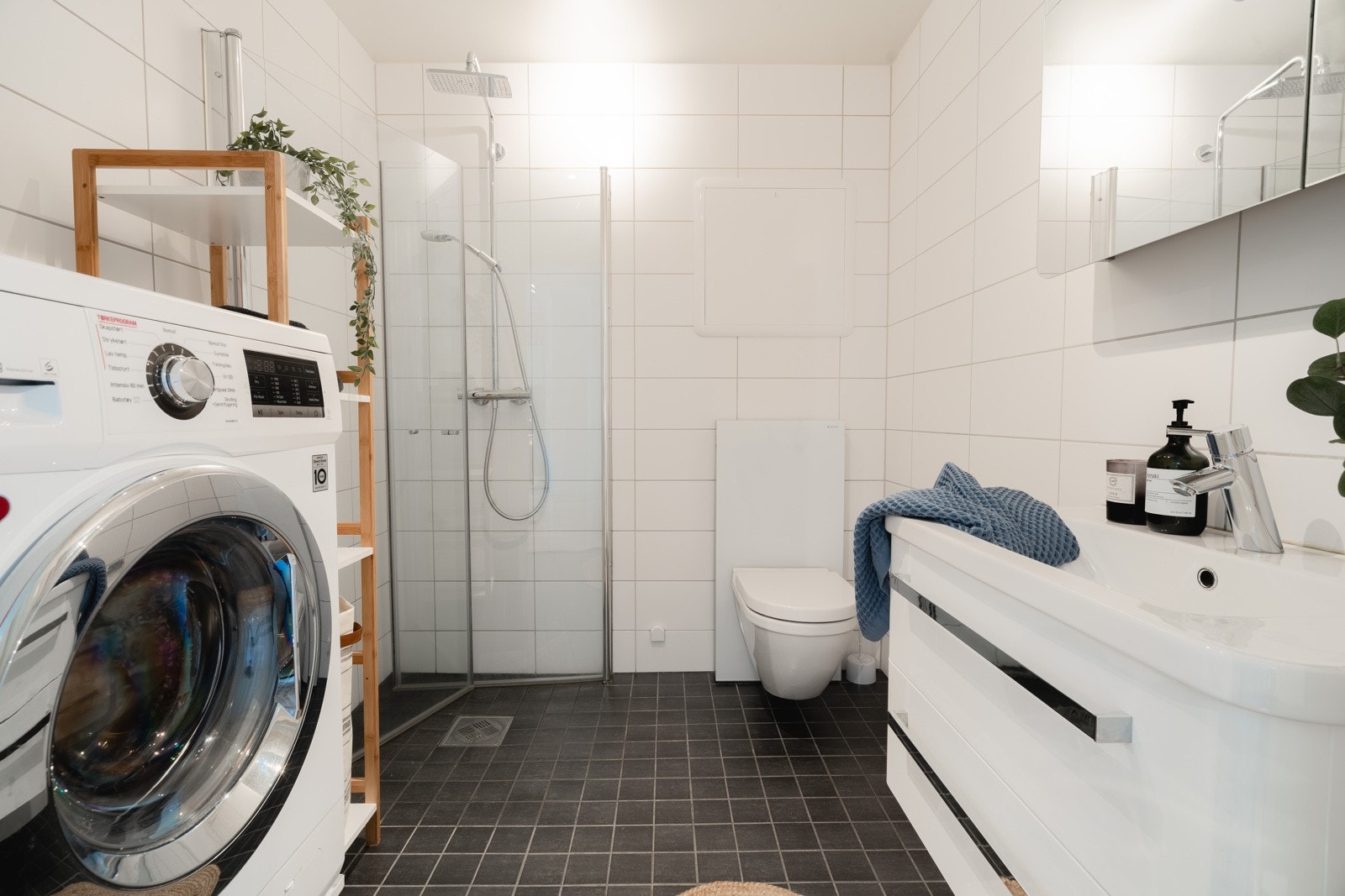 Komplett flislagt bad med vegghengt servant og toalett. Galleribilde