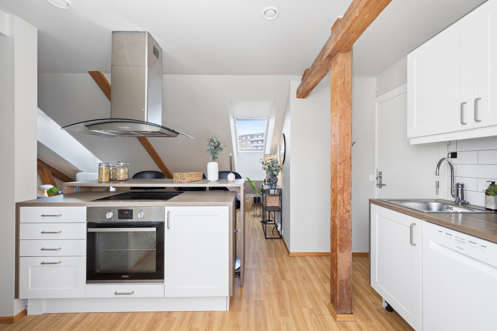 Kjøkken i åpen løsning mot stuen. Kjøkkenøy med komfyr, skuffer og skap. Takmontert ventilator. Galleribilde